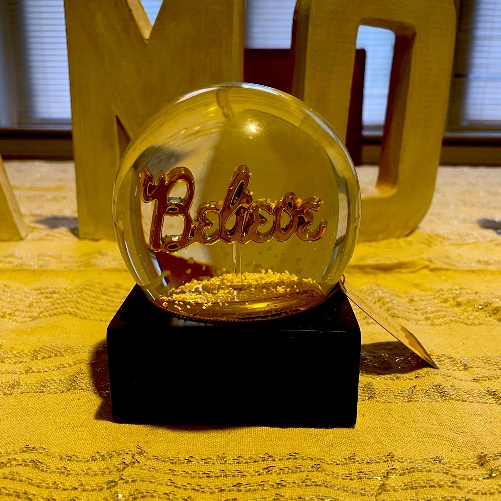 A golden Believe snow globe.